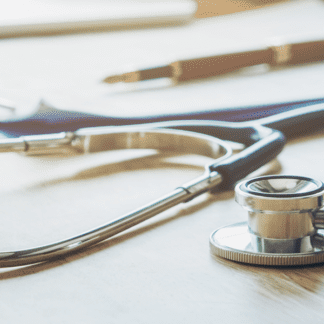 Stethoscope with clipboard and pen on desk