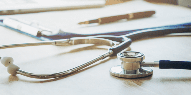 Stethoscope with clipboard and pen on desk